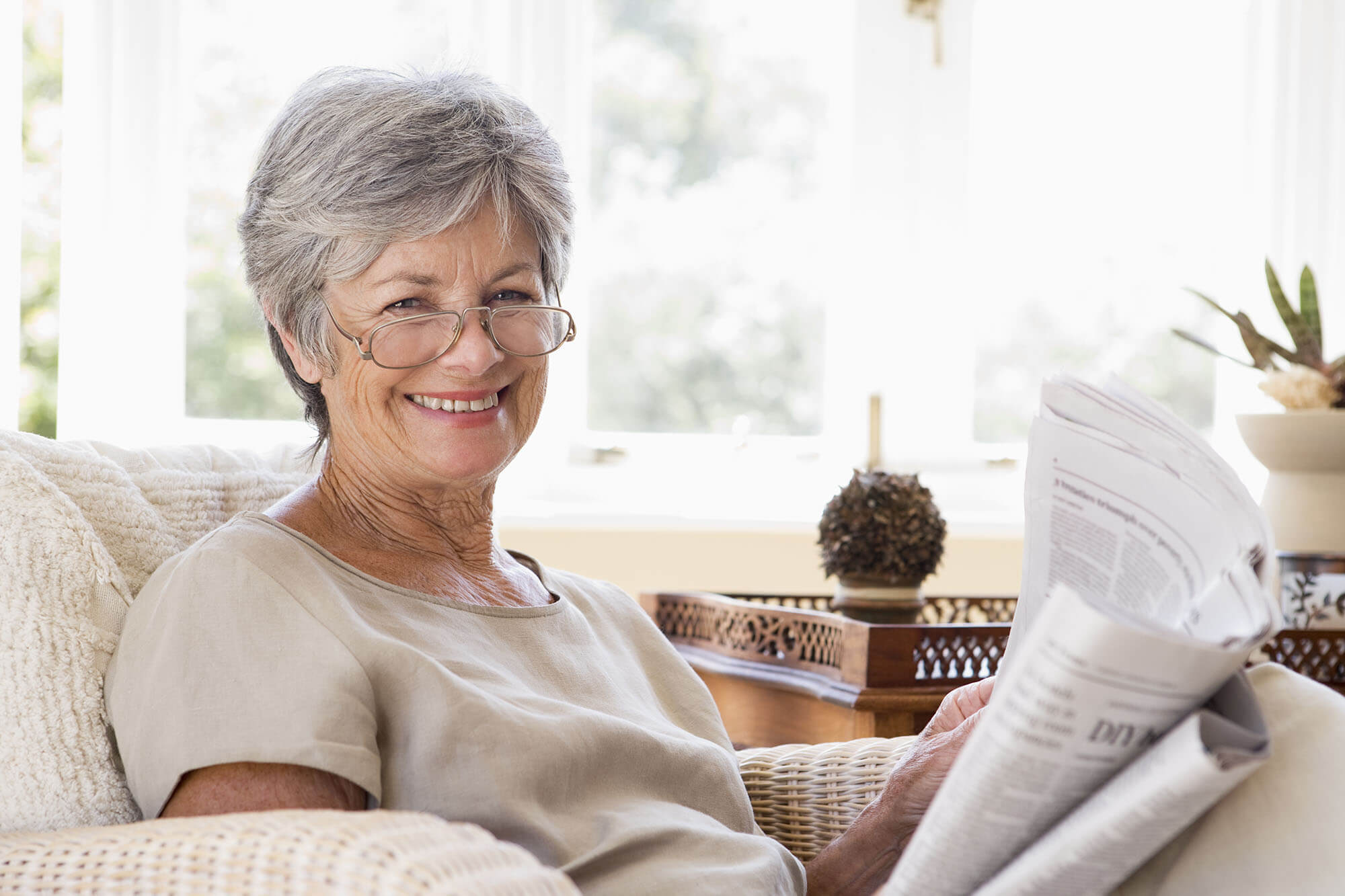 woman smiling reading newspaper